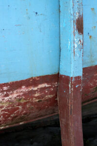 Photo, photographie de détail de coque de bateau du Finistère, marron ou rouge bordeaux, bleu, avec une béquille @ Christophe Pluchon
