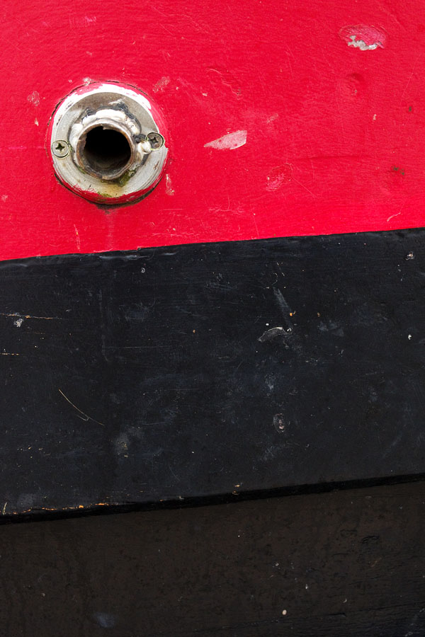 Photo, photographie de détail de coque de bateau du Finistère, rouge, noir, avec une évacuation couleur blanc @ Christophe Pluchon