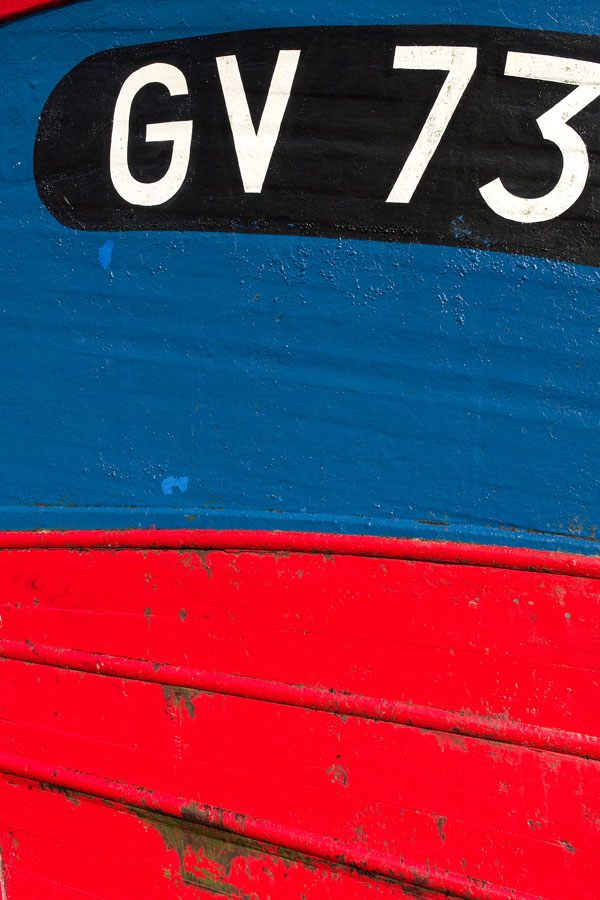Photo, photographie de détail de coque de bateau du Finistère, du quartier maritime du Guilvinec, rouge, noir et bleu @ Christophe Pluchon