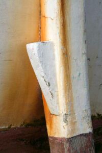 Photo, photographie de détail de coque de bateau du Finistère, blanc, rouge, bordeaux, rouille, orange, avec une béquille @ Christophe Pluchon