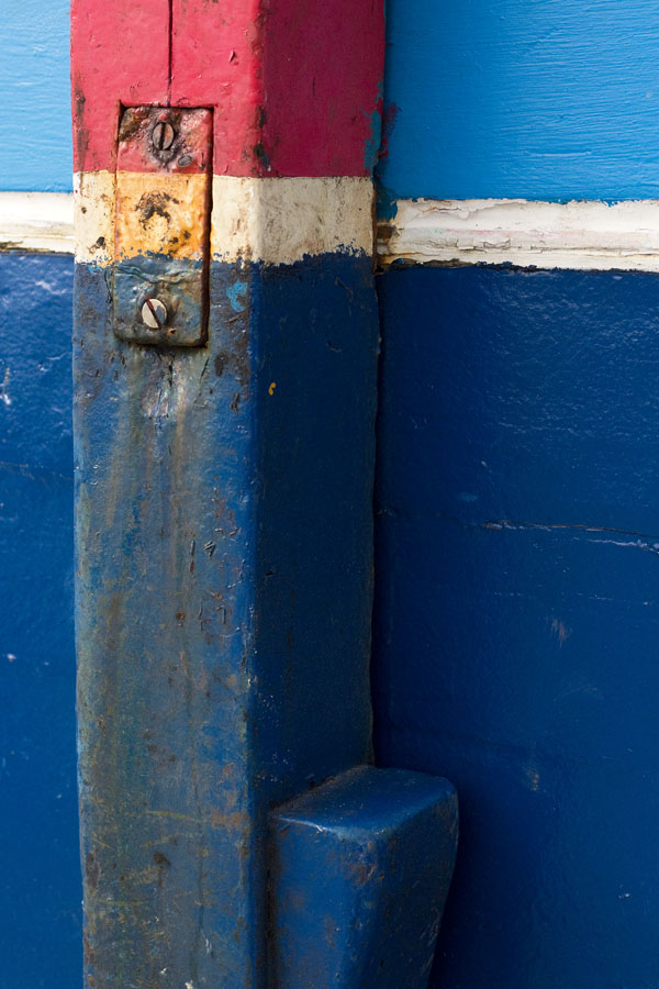 Photo, photographie de détail de coque de bateau du Finistère, bleu, blanc, rouge avec une béquille et un peu de rouille orange @ Christophe Pluchon