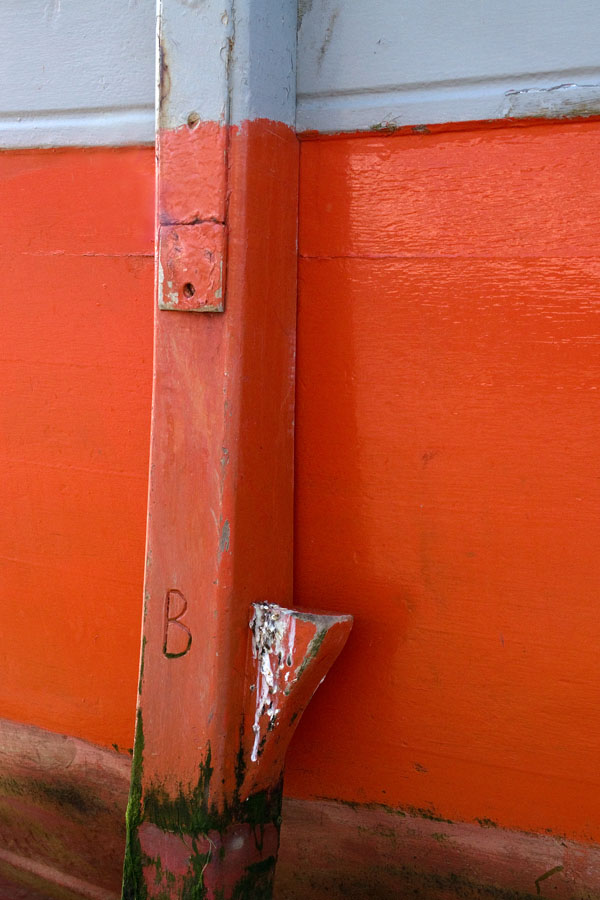 Photo, photographie de détail de coque de bateau du Finistère, gris, orange, avec une béquille orange et rouge @ Christophe Pluchon