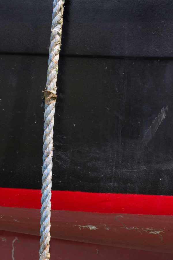 Photo, photographie de détail de coque de bateau du Finistère, rouge, noir, marron, bordeaux, avec une corde ou un cordage @ Christophe Pluchon