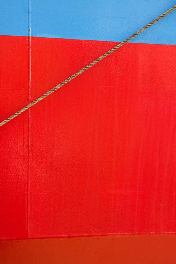 Photo, photographie de détail de coque de bateau du Finistère, rouge, bleu, gris, marron, avec une corde ou un cordage @ Christophe Pluchon
