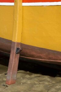 Photo, photographie de détail de coque de bateau du Finistère, orange, rouge, bordeaux, jaune, blanc, marron, avec une béquille @ Christophe Pluchon
