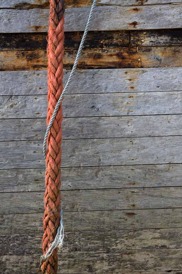 Photo, photographie de détail de coque de bateau du Finistère, gris, marron, orange, rouge, bleu, avec une corde ou un cordage @ Christophe Pluchon
