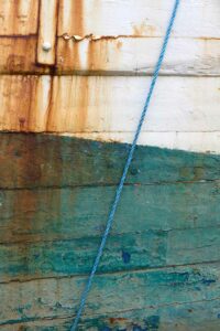 Photo, photographie de détail de coque de bateau du Finistère, bleu, blanc, orange, vert, rouille, avec une corde ou un cordage @ Christophe Pluchon