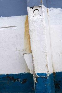 Photo, photographie de détail de coque de bateau du Finistère, blanc, bleu, orange, rouille, avec une béquille @ Christophe Pluchon